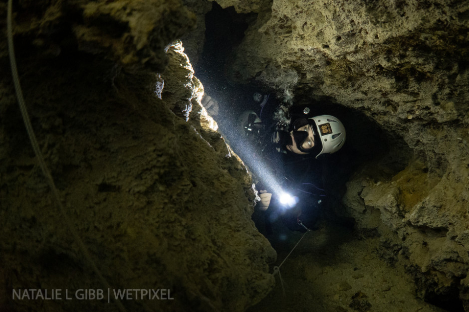 Bre Kramer slides through a tight restriction at Cenote Caterpillar. 