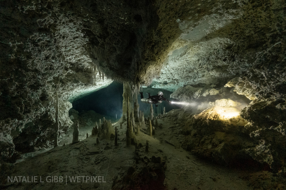 A light placed behind a conveniently located column create a sunburst effect for diver Bre Kramer at Cenote Caterpillar. 