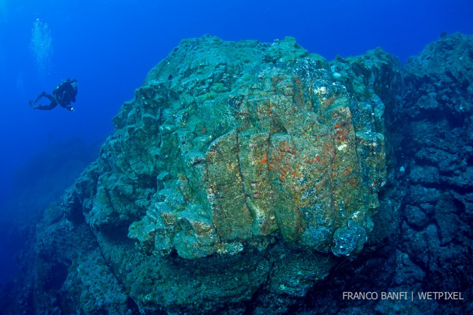 Scuba diver exploring the rocks formation at Formigas Islet dive site, 27 miles northeast of Santa Maria Island, Azores, Atlantic Ocean.