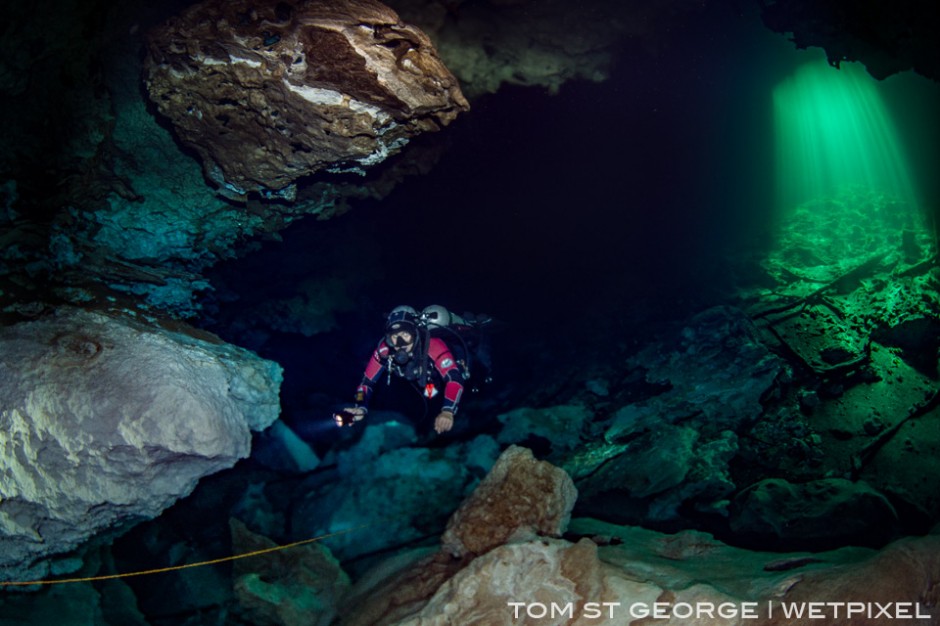 Cenote Calavera with the sun streaming through the entrance in the background.